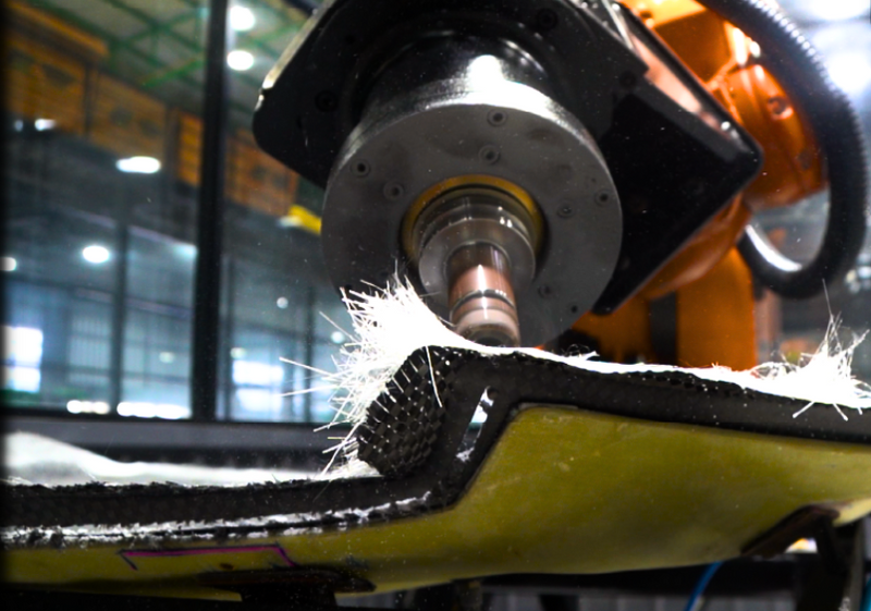 Industrial machining tool trimming material from a composite panel edge